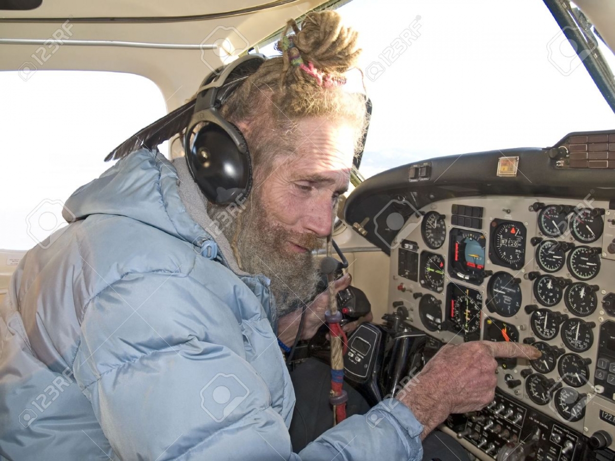Strange-older-pilot-with-a-feather-in-his-dreadlocks-reading-the-instruments-Stock-Photo.jpg